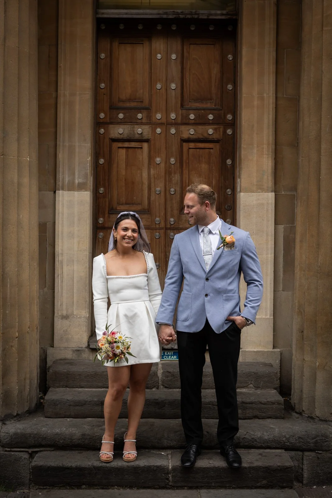 bride and groom stand on steps Bath City Centre