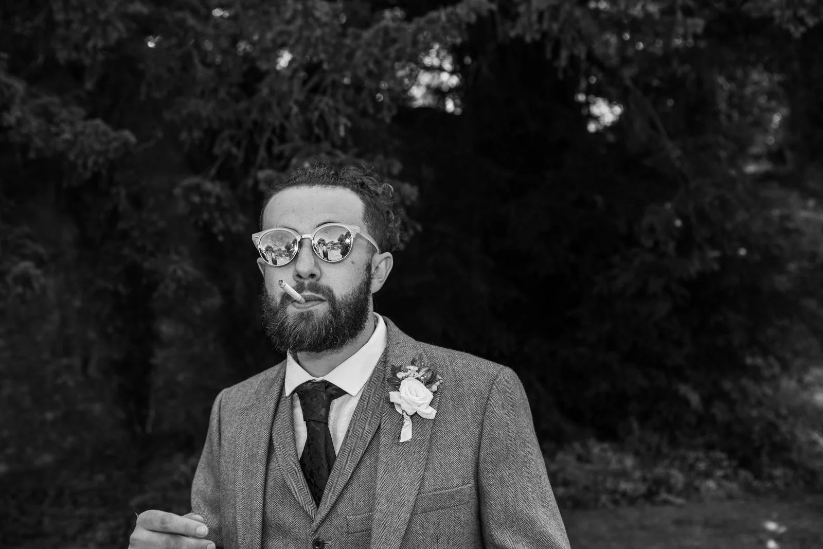 wedding guest smokes cigarette outside church 