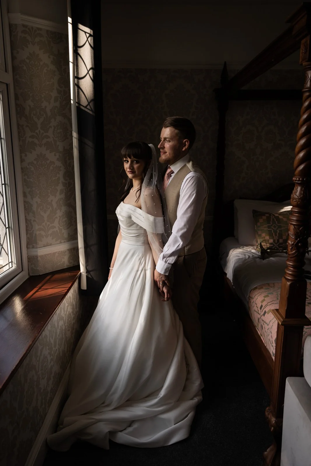 bride and groom standing in front of window at Llechwen Hall