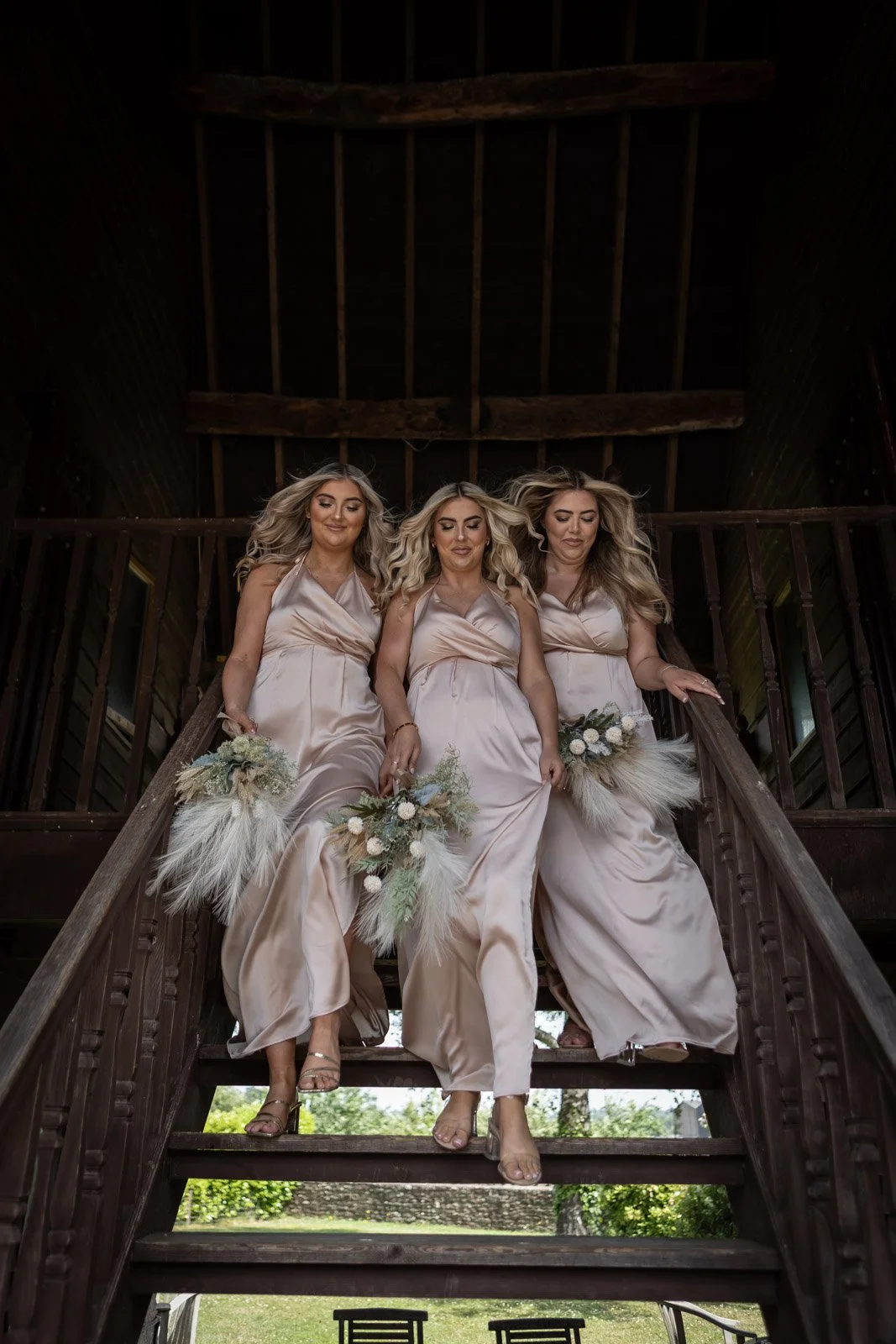 bridesmaids striding down stairs after bridal preparations