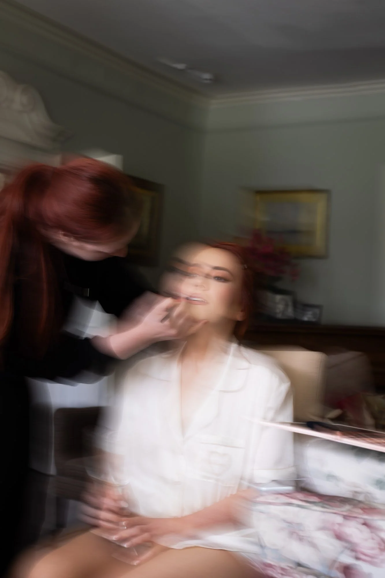Blurred shot of bride having make up done in manor house 