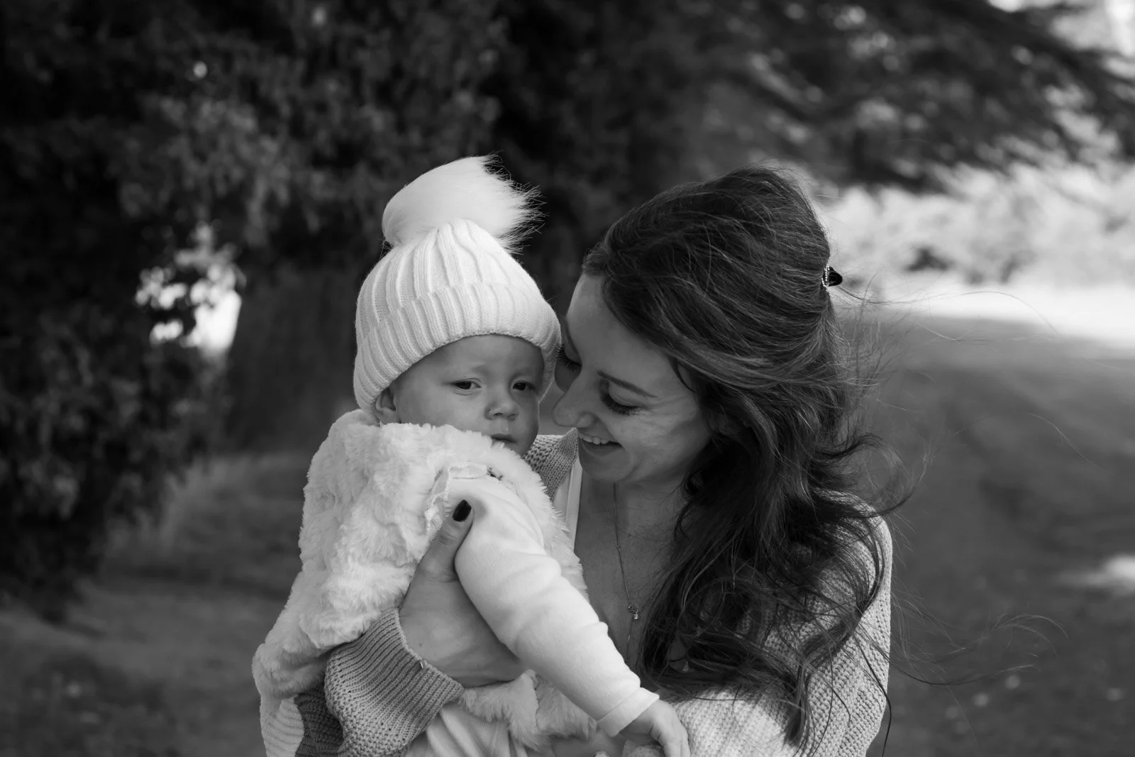 mum holds toddler daughter and looks at her smiling