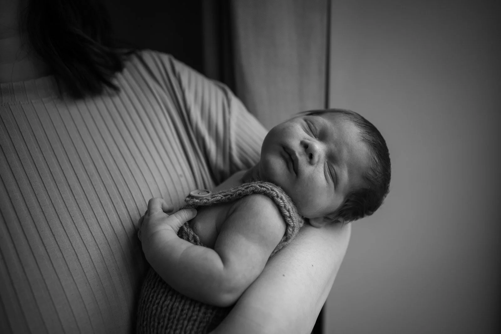 baby sleeps with head tilted back on mum's forearm