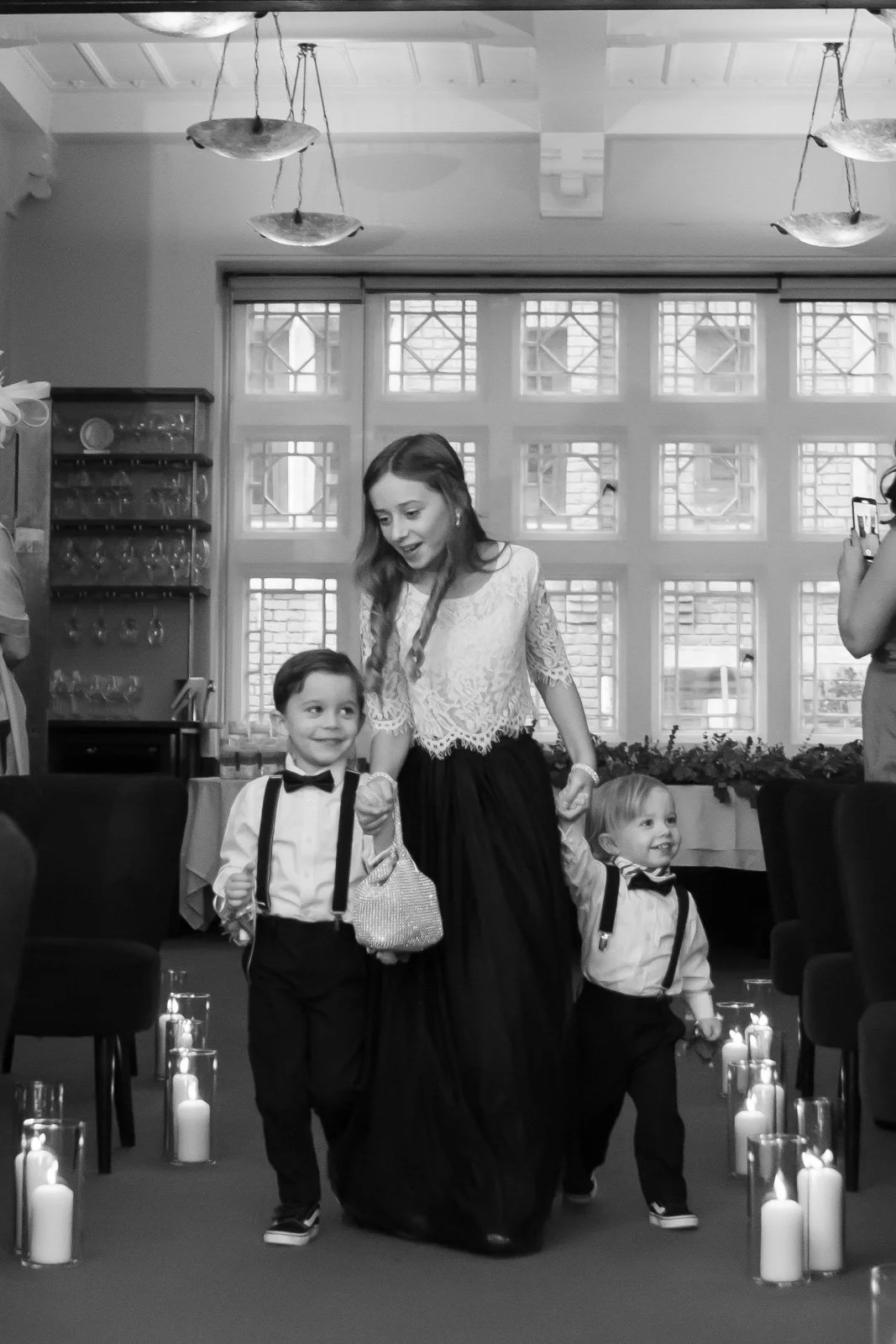 flower girl leads young page boys down the aisle at the start of marriage proceedings