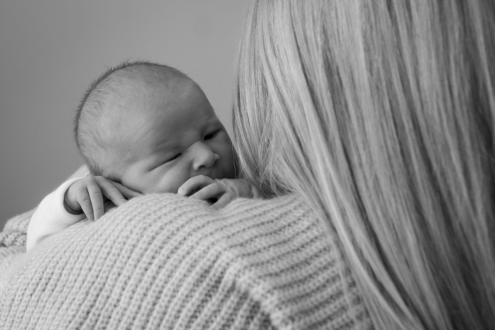 baby girl sleeps on mother's shoulder