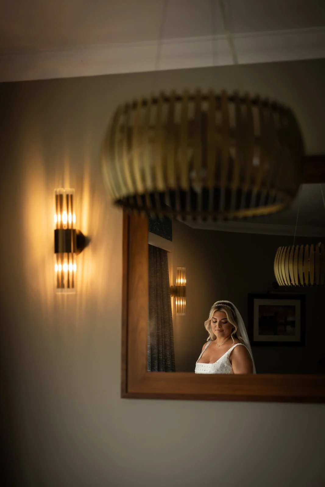 bride looks over shoulder in mirror at The Celtic Manor Resort