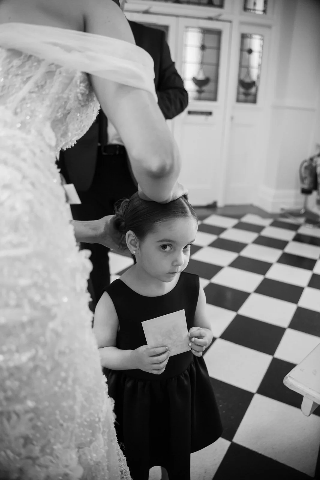 bride adjusts flower girls hair