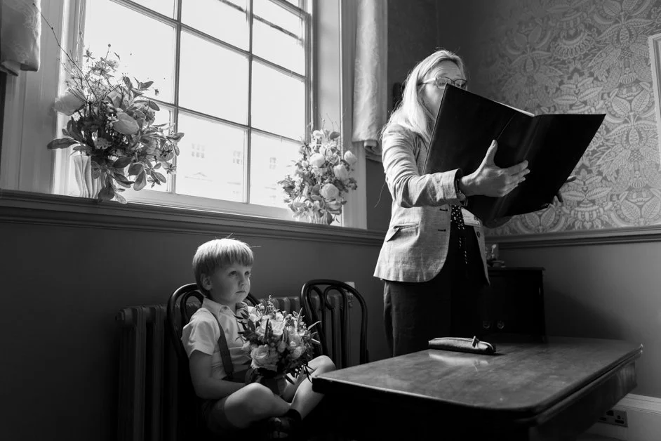 son of bride and groom holds bouquet