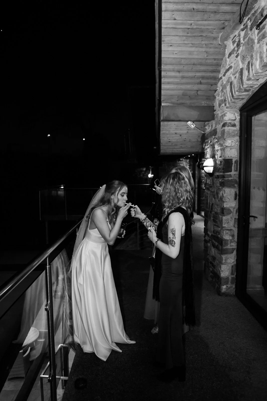 bride smokes cigarette outside at wedding party