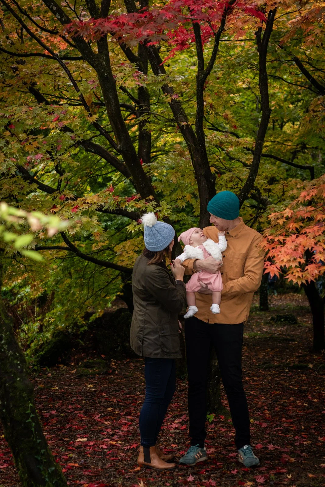 family pose for photograph amongst autumn trees
