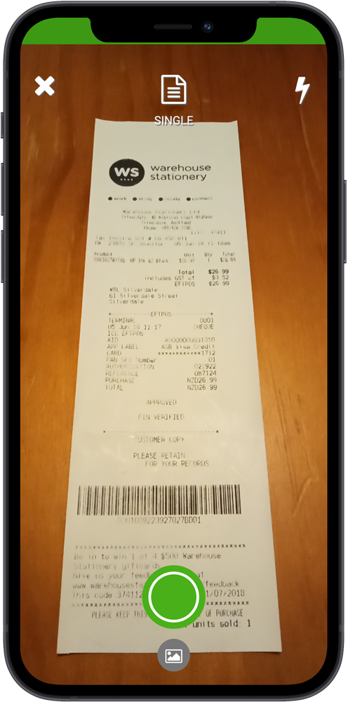 QuickBooks Online mobile app camera view capturing a paper receipt, with green frame indicating the receipt is detected and ready to photograph