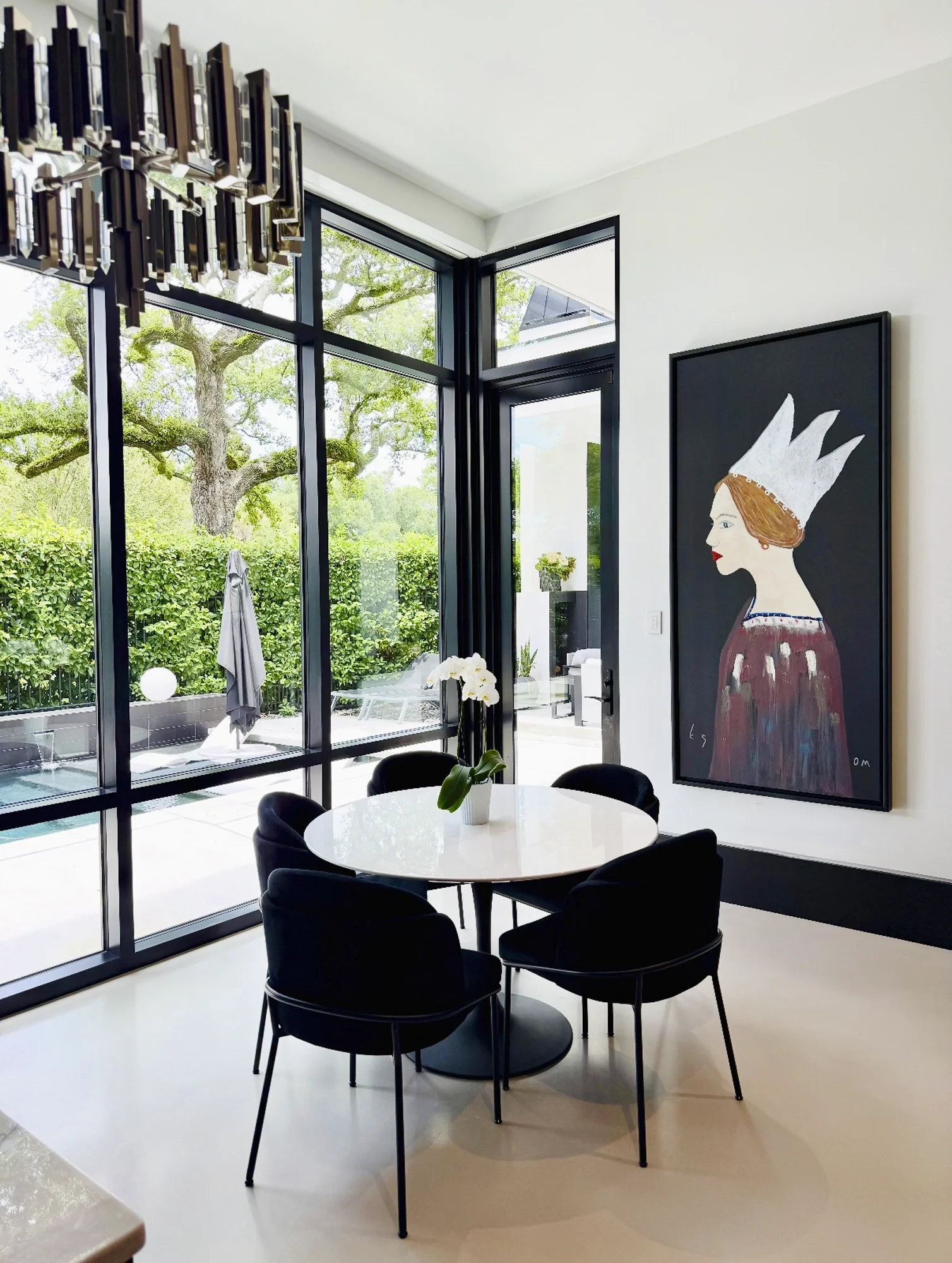 A figurative painting from Tony Mose installed on the wall of a modern home dining area.