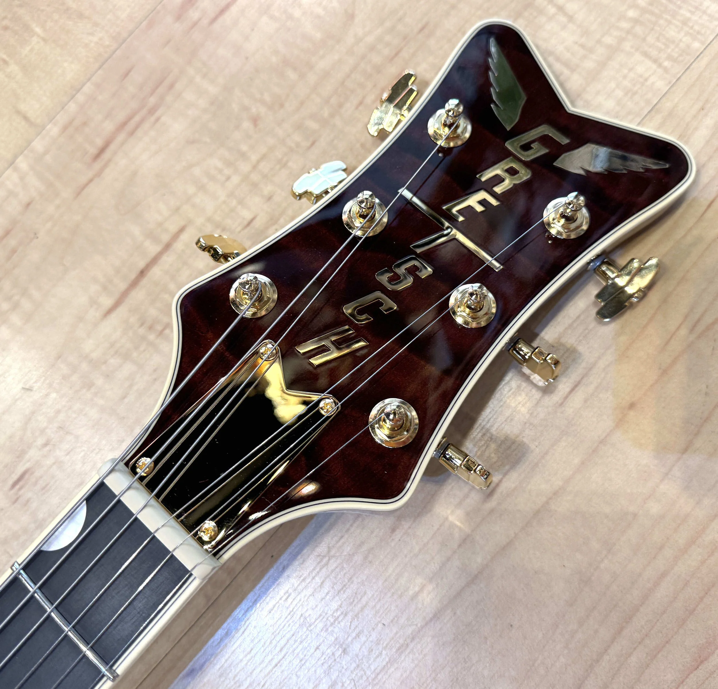 Headstock of the Gretsch Limited Edition Falcon Center Block Jr. with Bigsby Quilted Maple Top In Roundup Orange