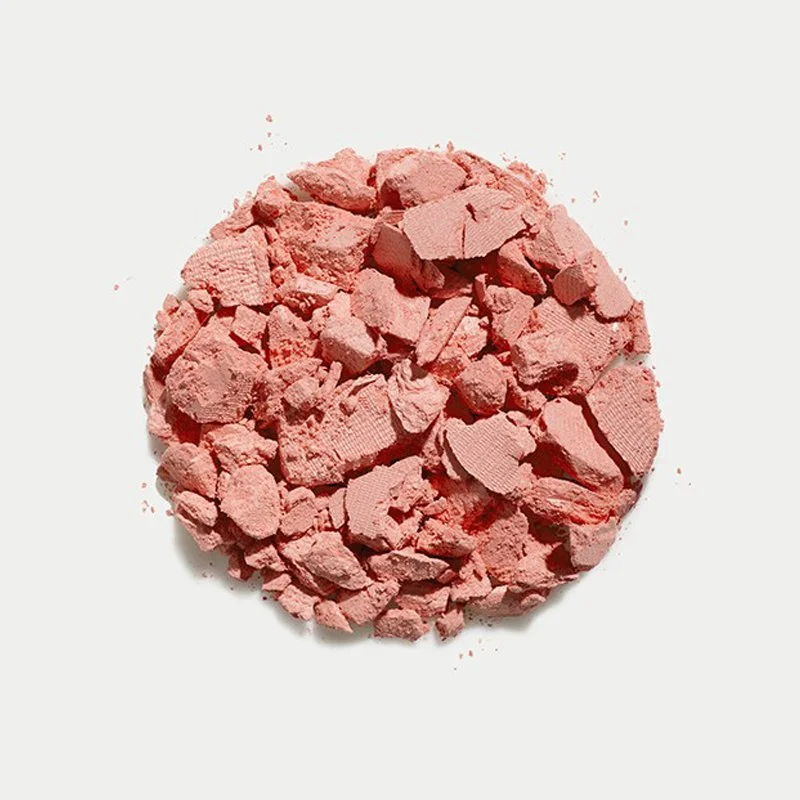Pink powder or crushed makeup product on a white background.