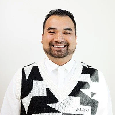 Professional headshot of Eric Diep, a smiling man with short dark hair and a goatee, wearing a black and white geometric patterned sweater over a white collared shirt.