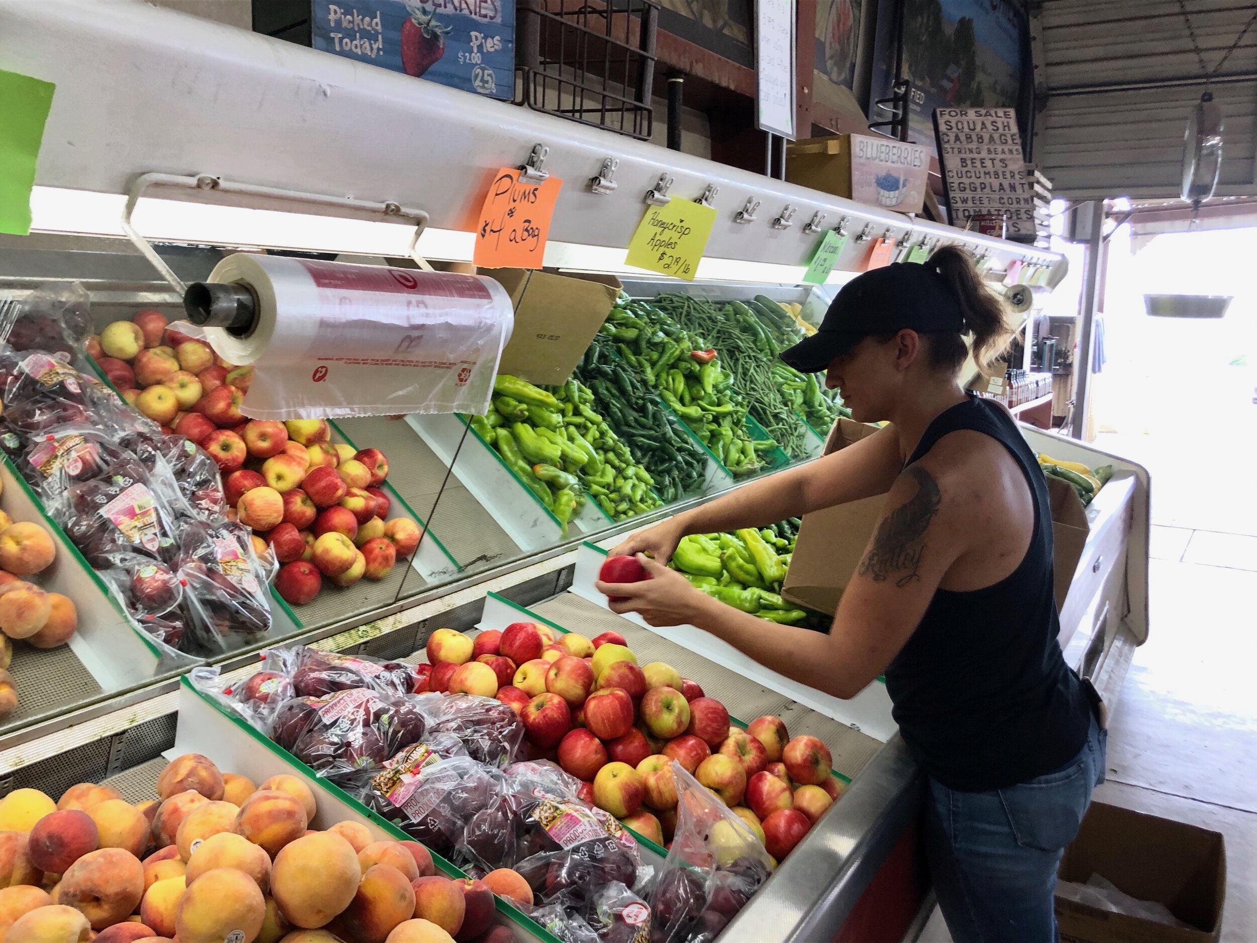  Kasey Hund, manager of DiTomaso Farms, stores produce on the shelves of the DiTomaso Farms fruit stand. 
