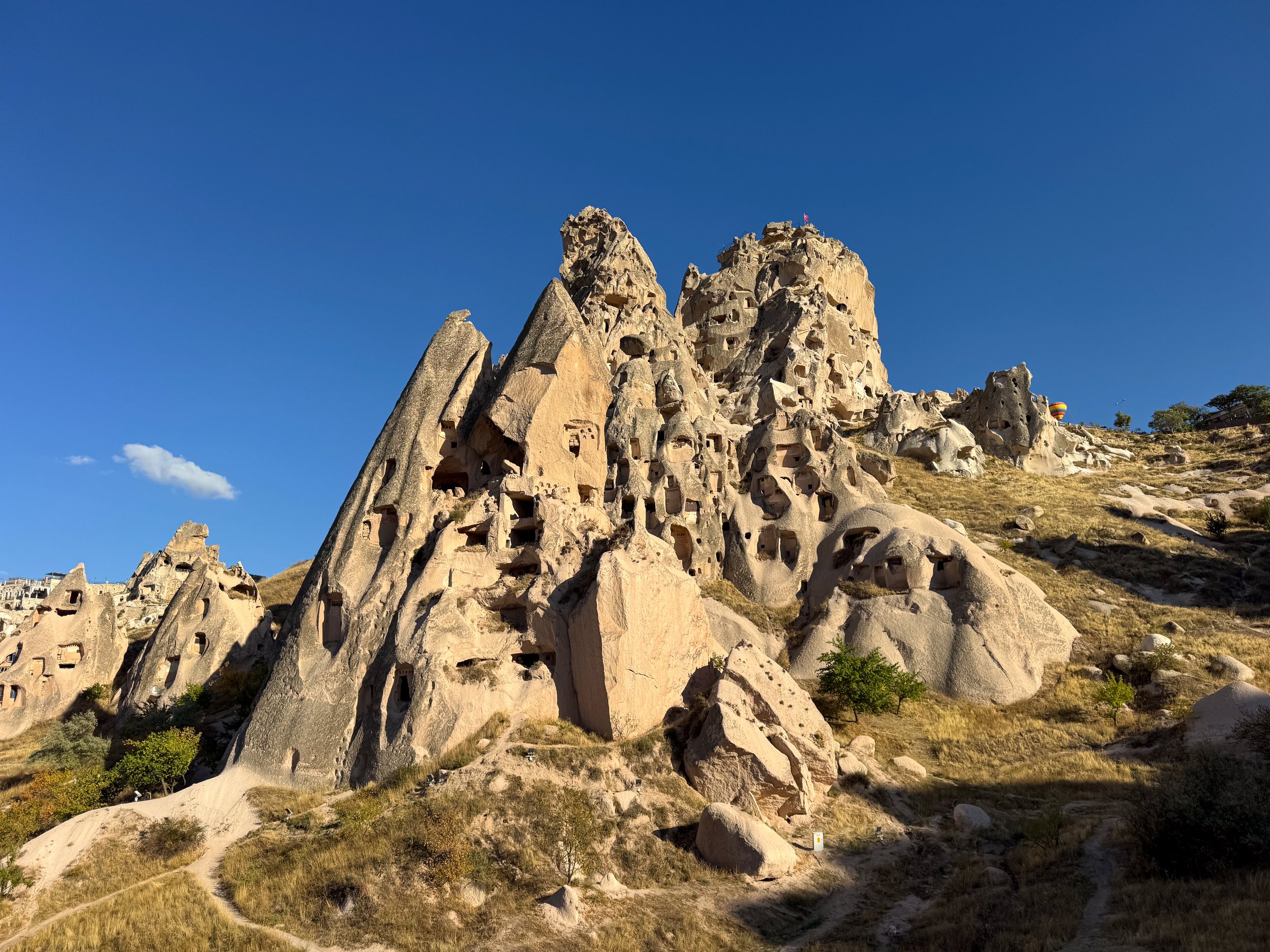 Large volcanic tufa rock formation riddled with ancient carved cave openings in Cappadocia.
