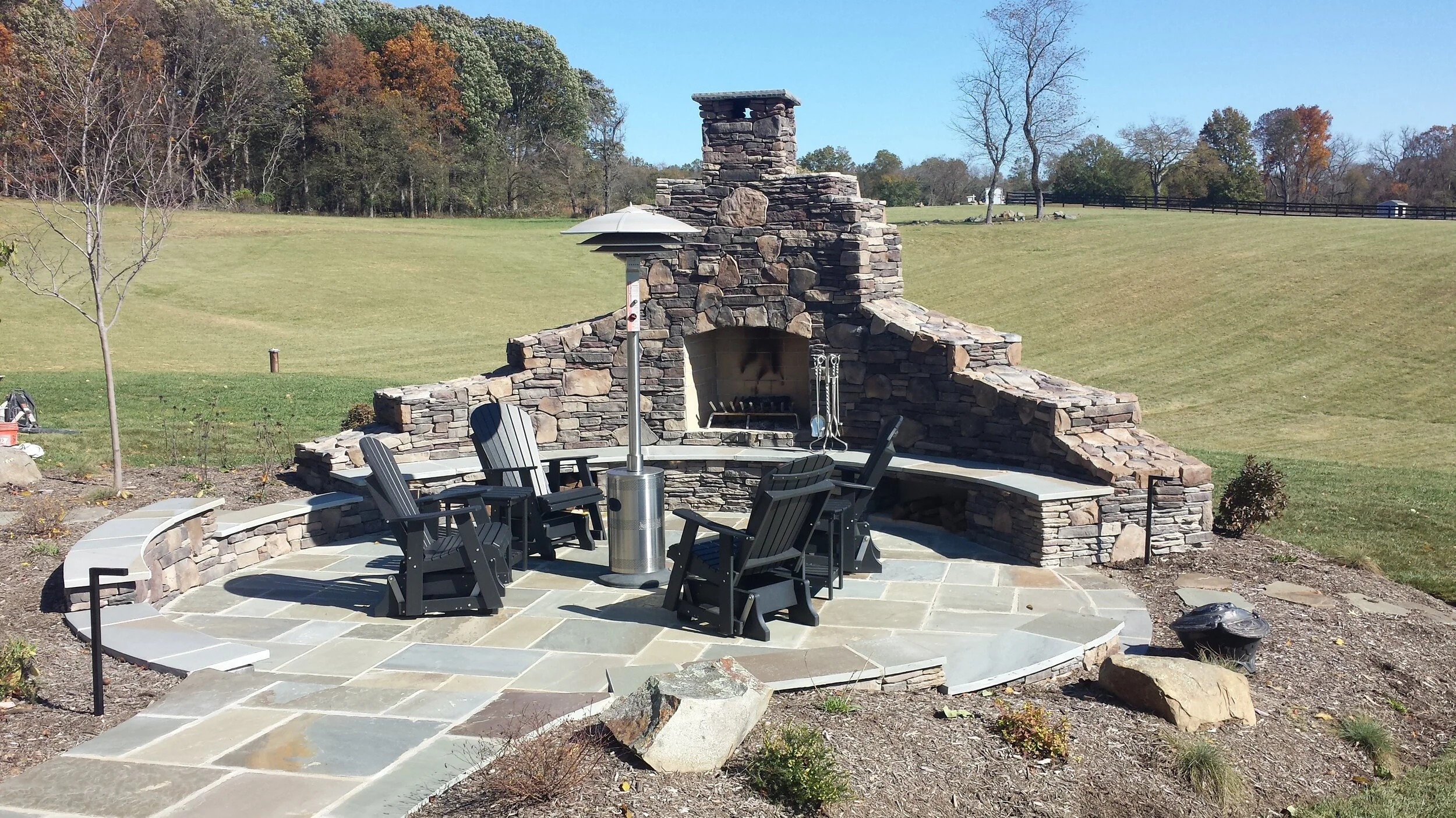 Outdoor fireplace, bench seating, natural flagstone patio and landscape lighting.