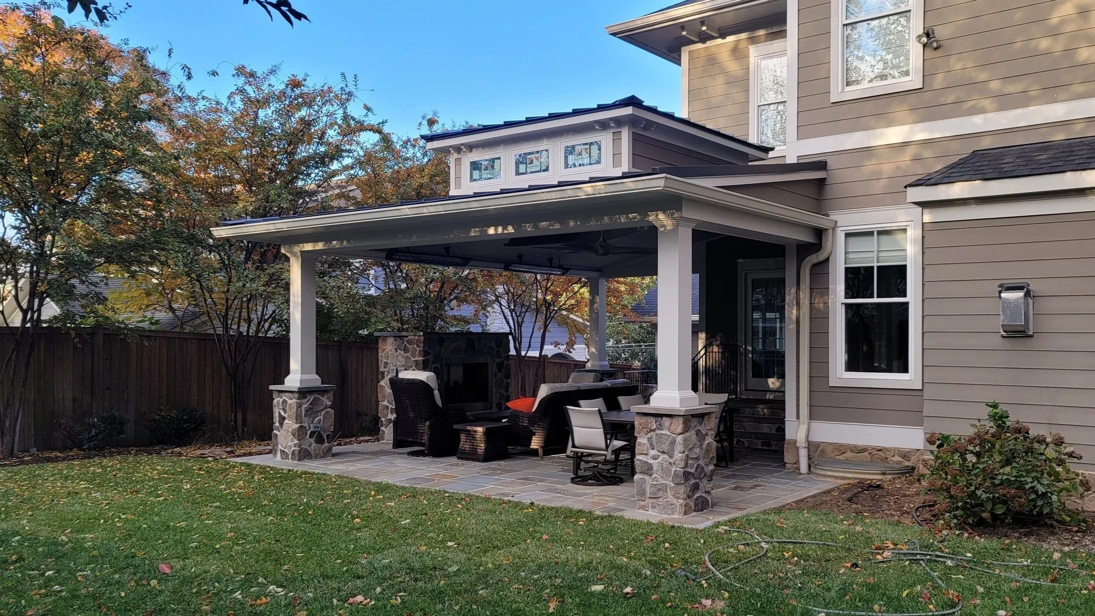 Outdoor living space with fireplace, ceiling fans