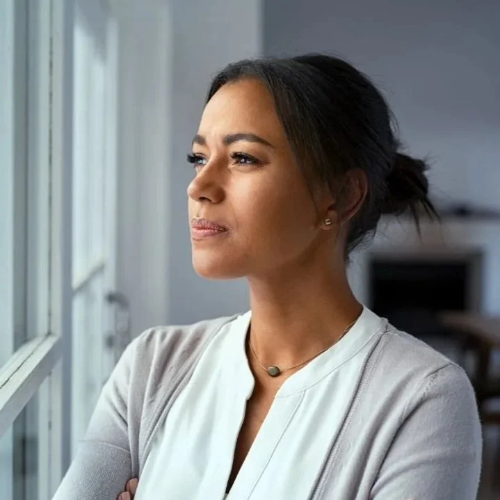 Person sitting quietly in a calm room while feeling anxious during a peaceful moment.