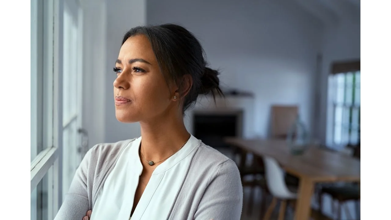 woman looking out window thinking about choices
