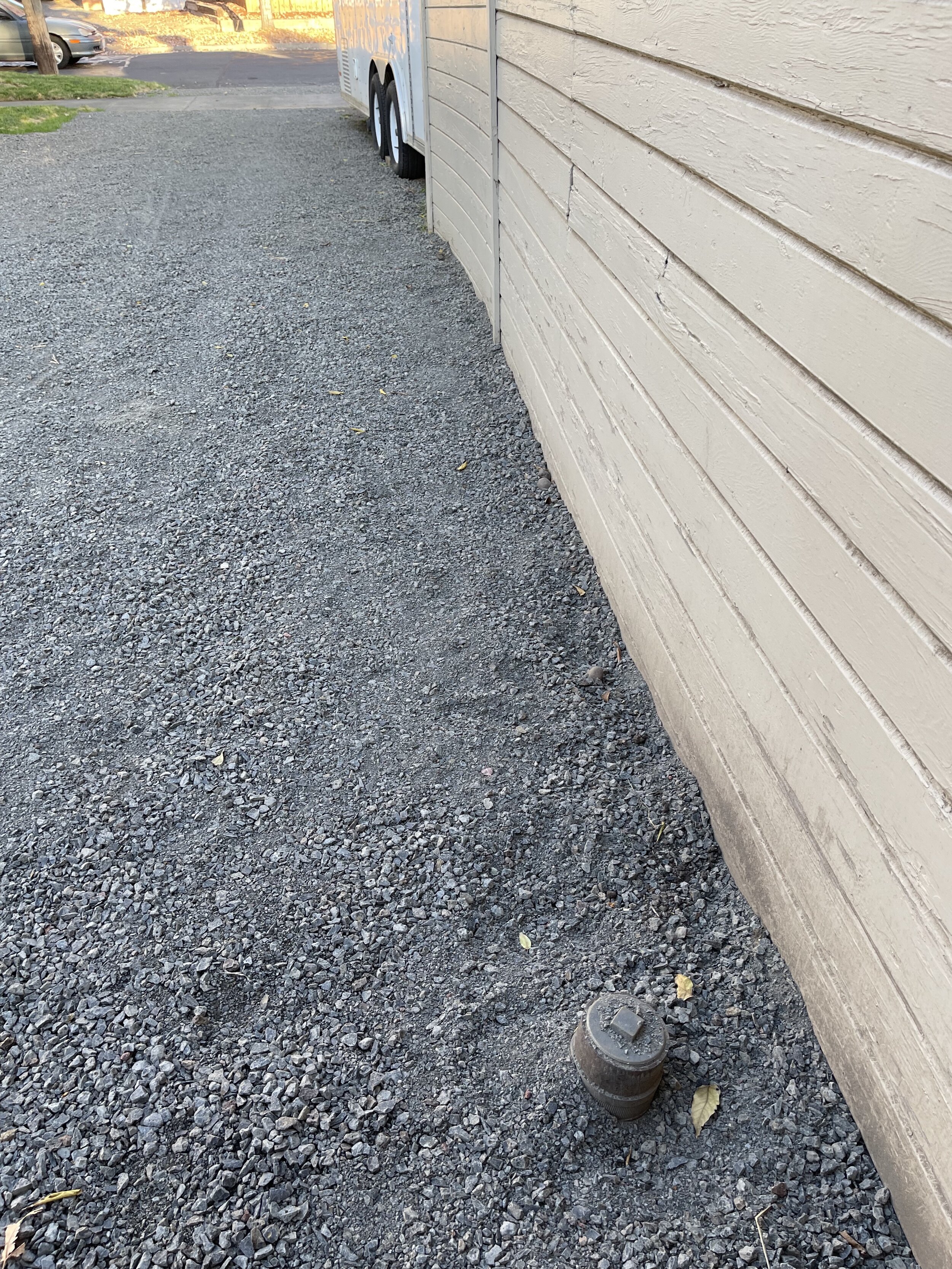 This looks like a sewer cleanout. Took picture as I'm not sure why there would be one here, and to show that neighbor's garage is right on top of the property line.
