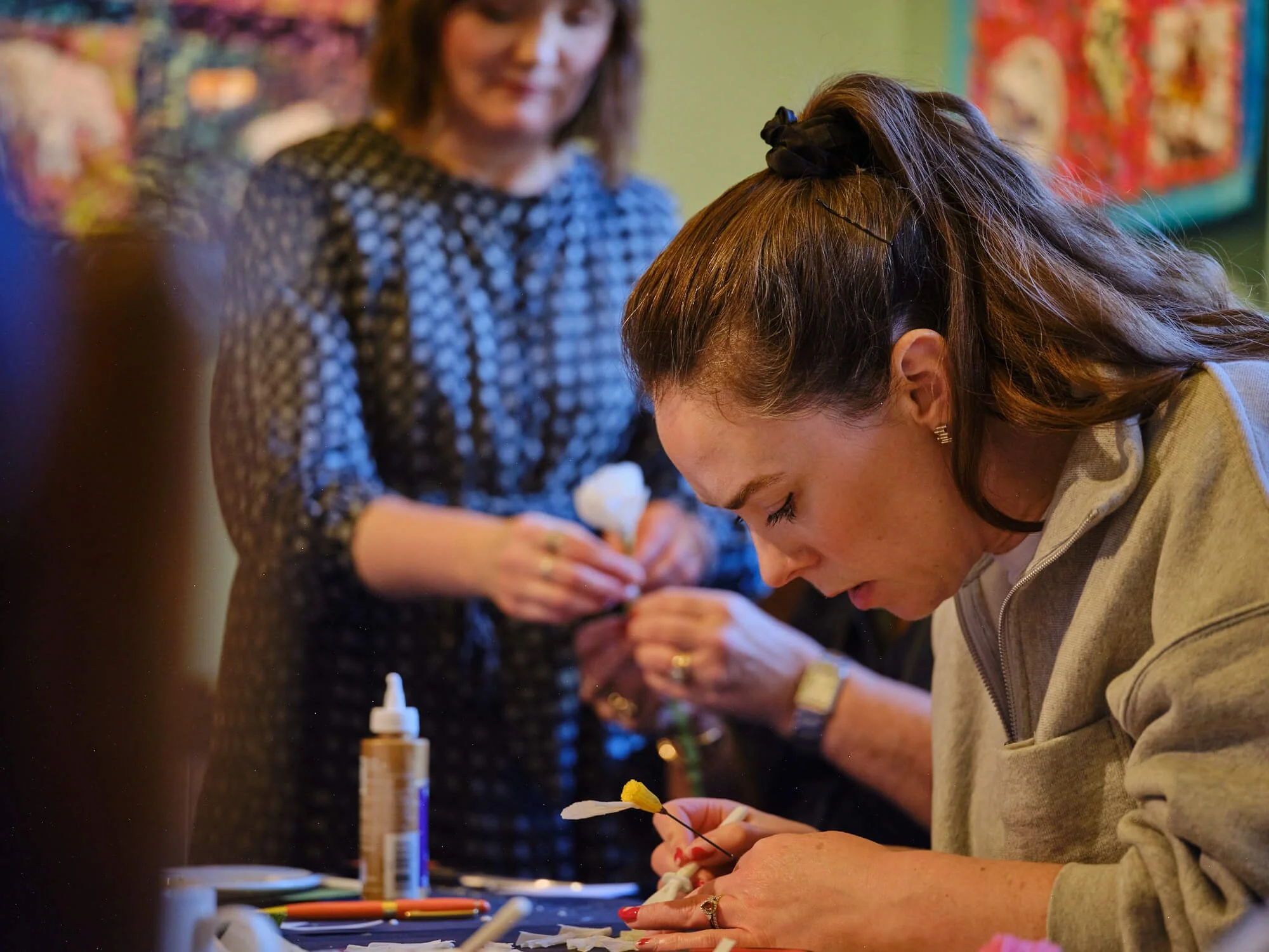 student making at table paper flower workshop