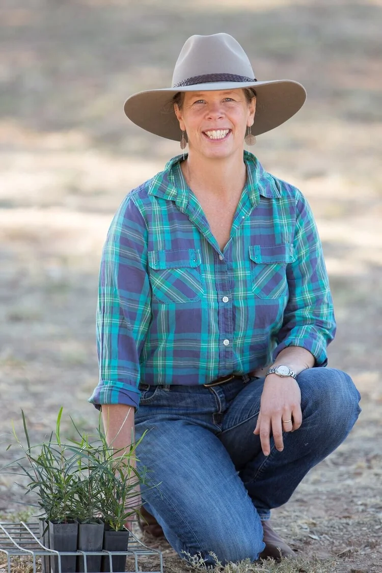 Fiona Murdoch kneeling beside seedlings at Raakajilm