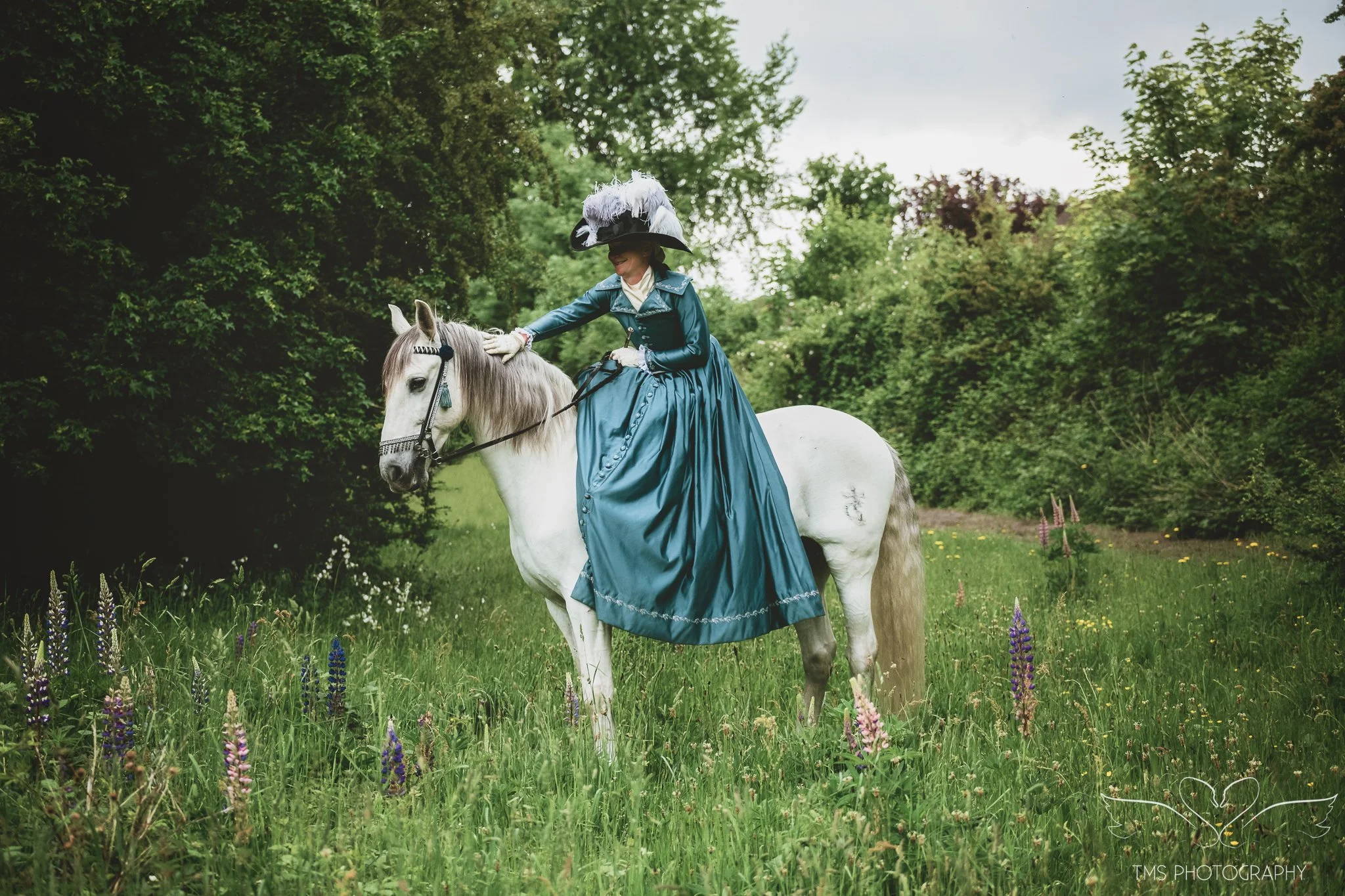 Spanish PRE horse Querberin standing with side saddle rider in period costume
