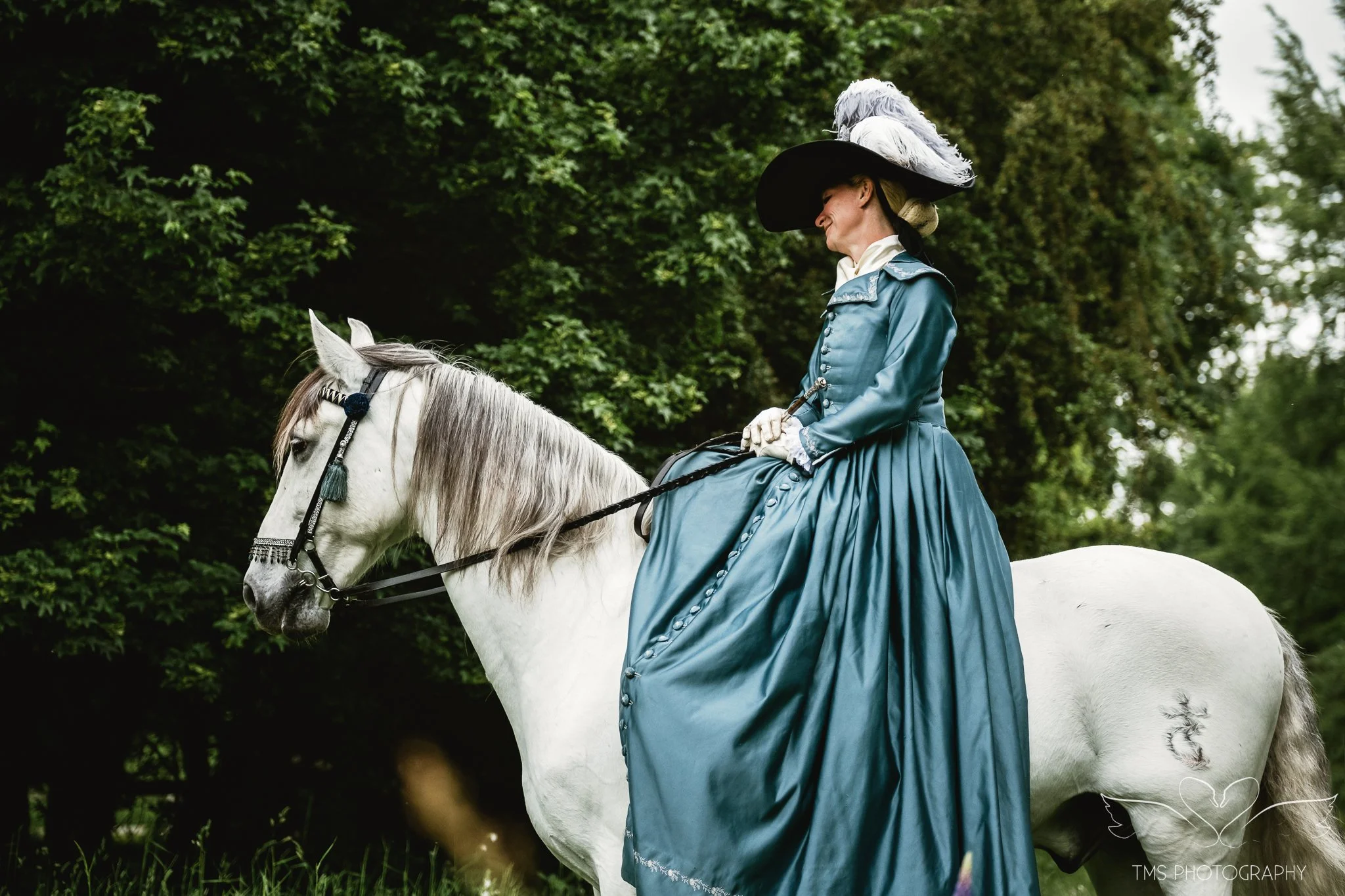 Eighteenth century inspired side saddle outfit with feathered hat and PRE horse