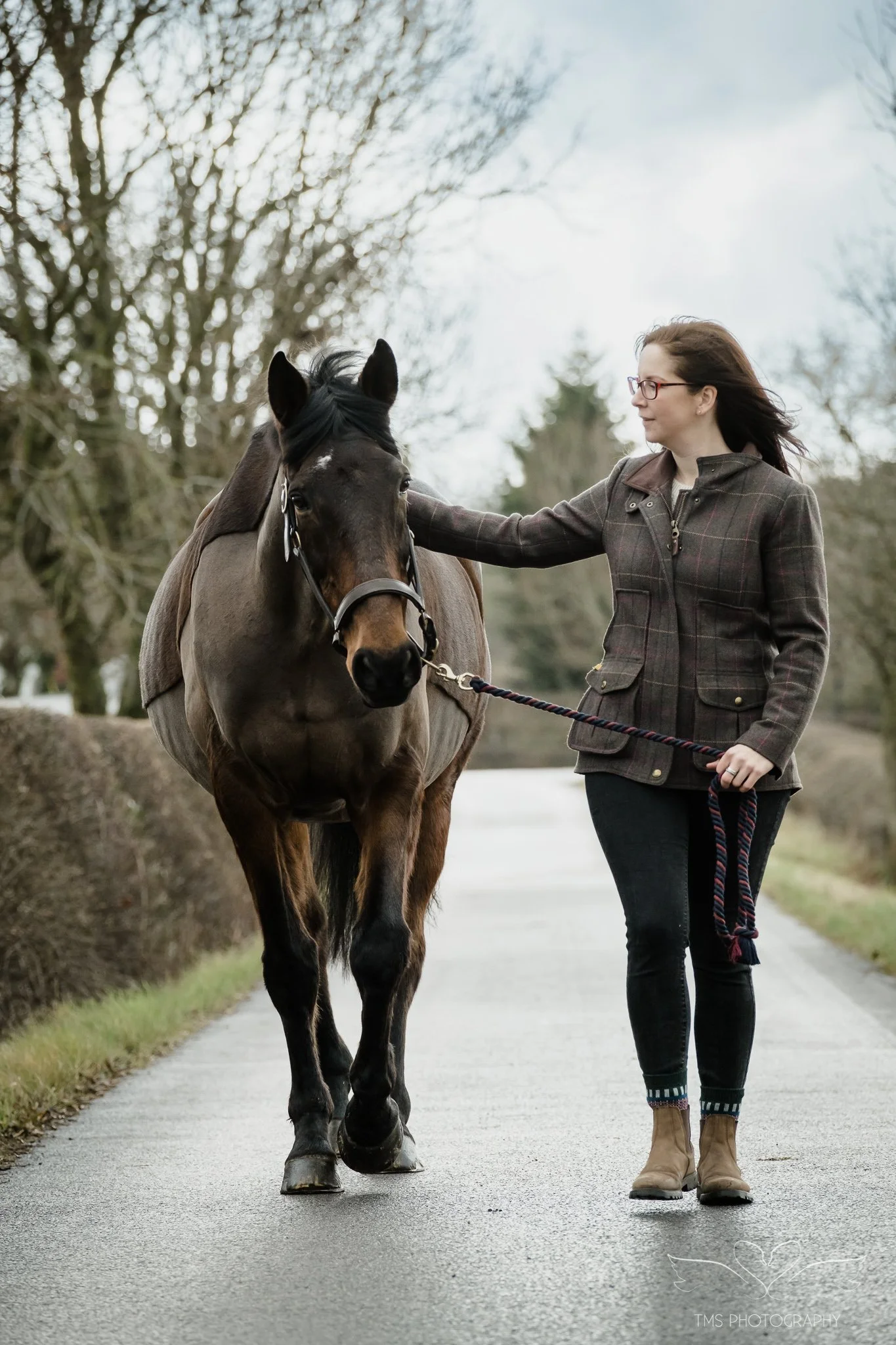 woman walking with her horse down a driveway in Hartshorne