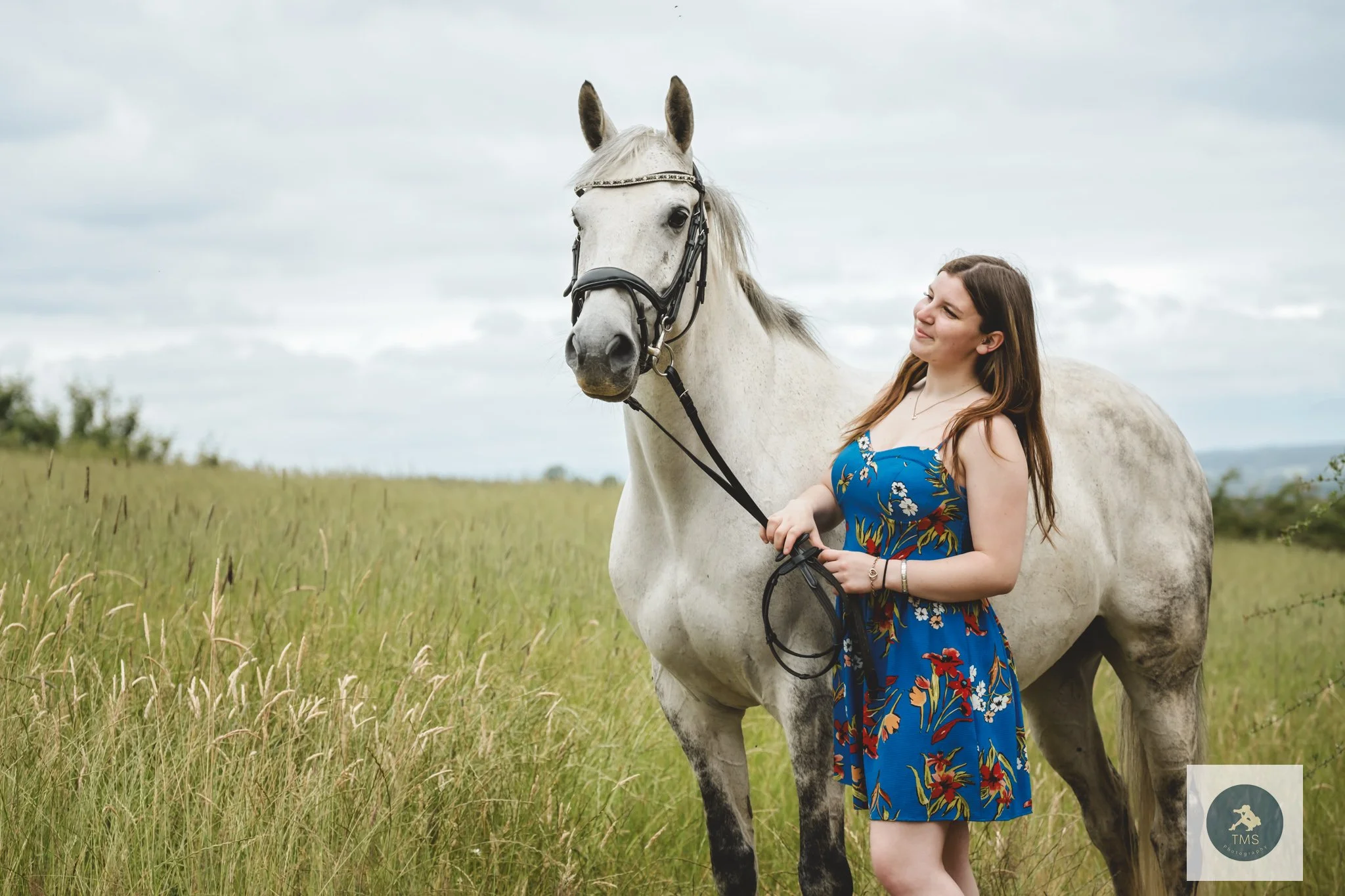 Liv wearing a summer dress beside her horse Milly