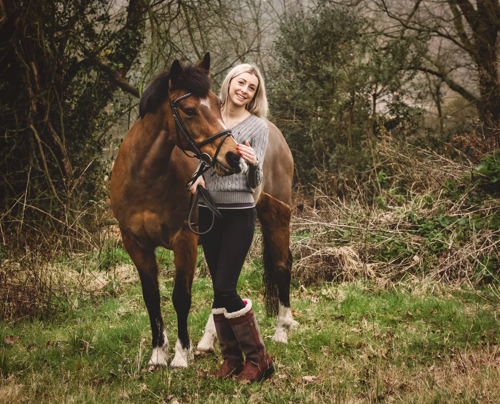 Horse and owner standing together at livery yard UK