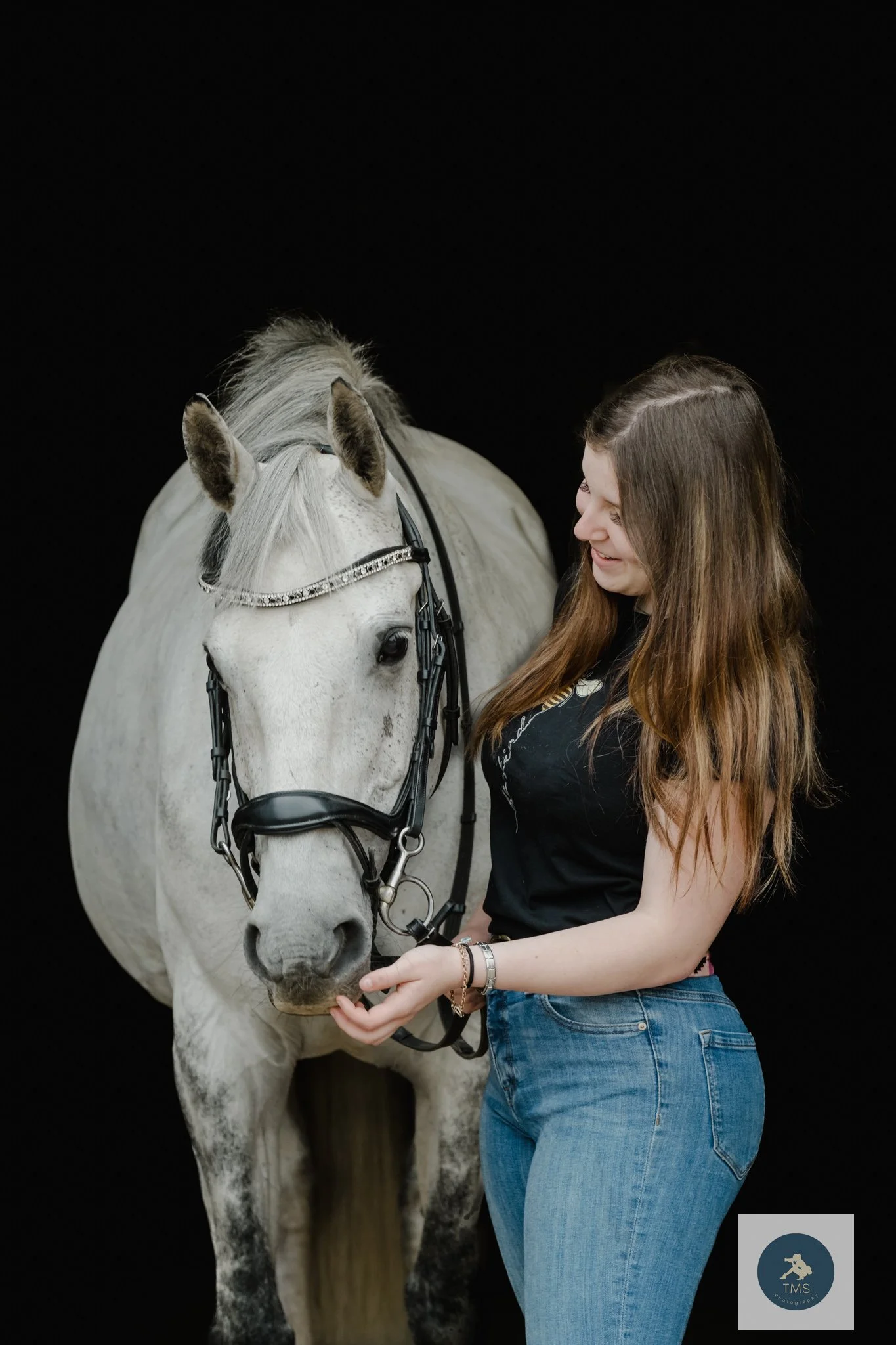 Liv wearing jeans and a T-shirt with her horse Milly