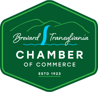 Logo for Brevard County Transylvania Chamber of Commerce with a green shield, a blue water stream, and white text.