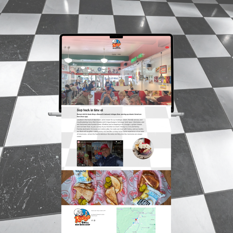 Image of a laptop on a black and white tiled floor showing a webpage about Rocky's Grill and Soda Shop, featuring images of a restaurant and food items like sandwiches and desserts.