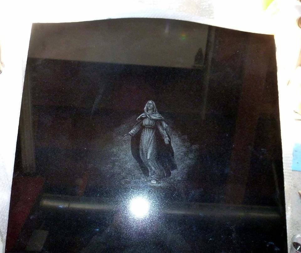 Engraving of a medieval monk on a reflective black surface
