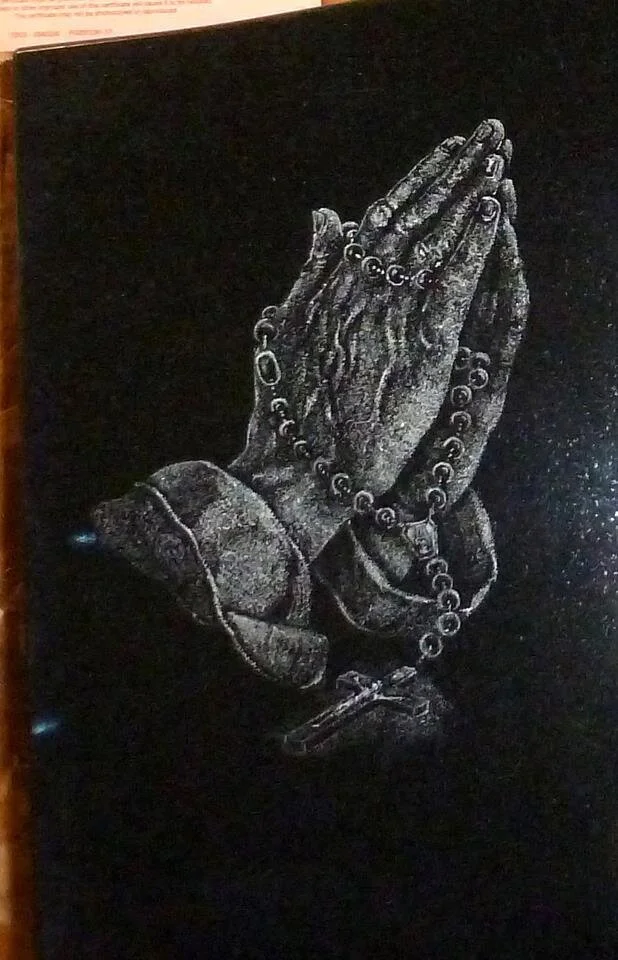 Illustration of hands in prayer with rosary beads on black background
