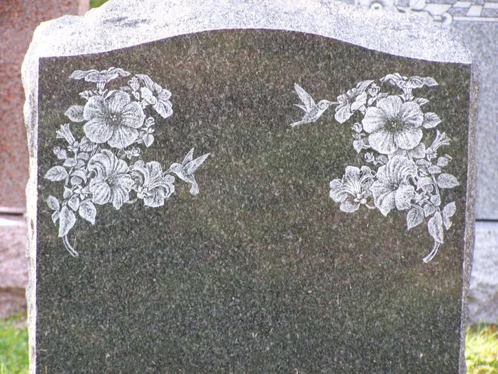 Blank tombstone with floral and hummingbird engravings