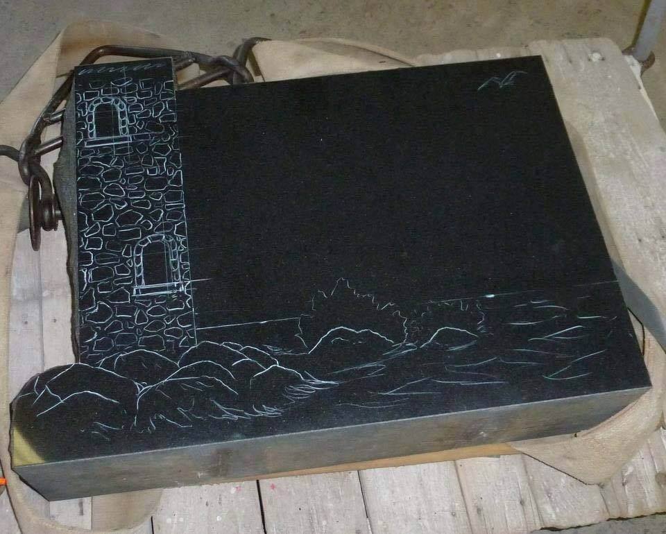 Engraved stone slab with lighthouse and ocean scene