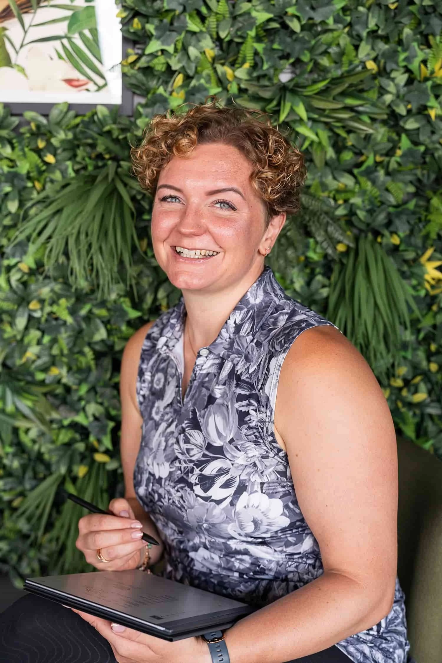 photo of Rowena Ramsell, standing against a green foliage wall looking friendly and happy