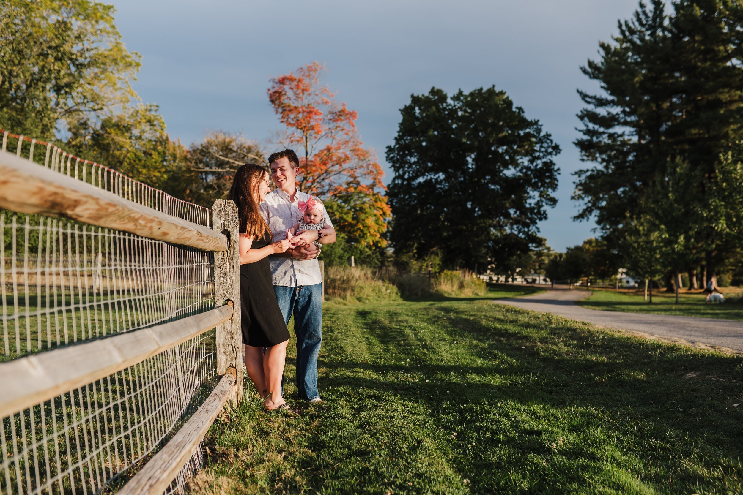 Parents and baby alongside a fence at Knox Farm in East Aurora