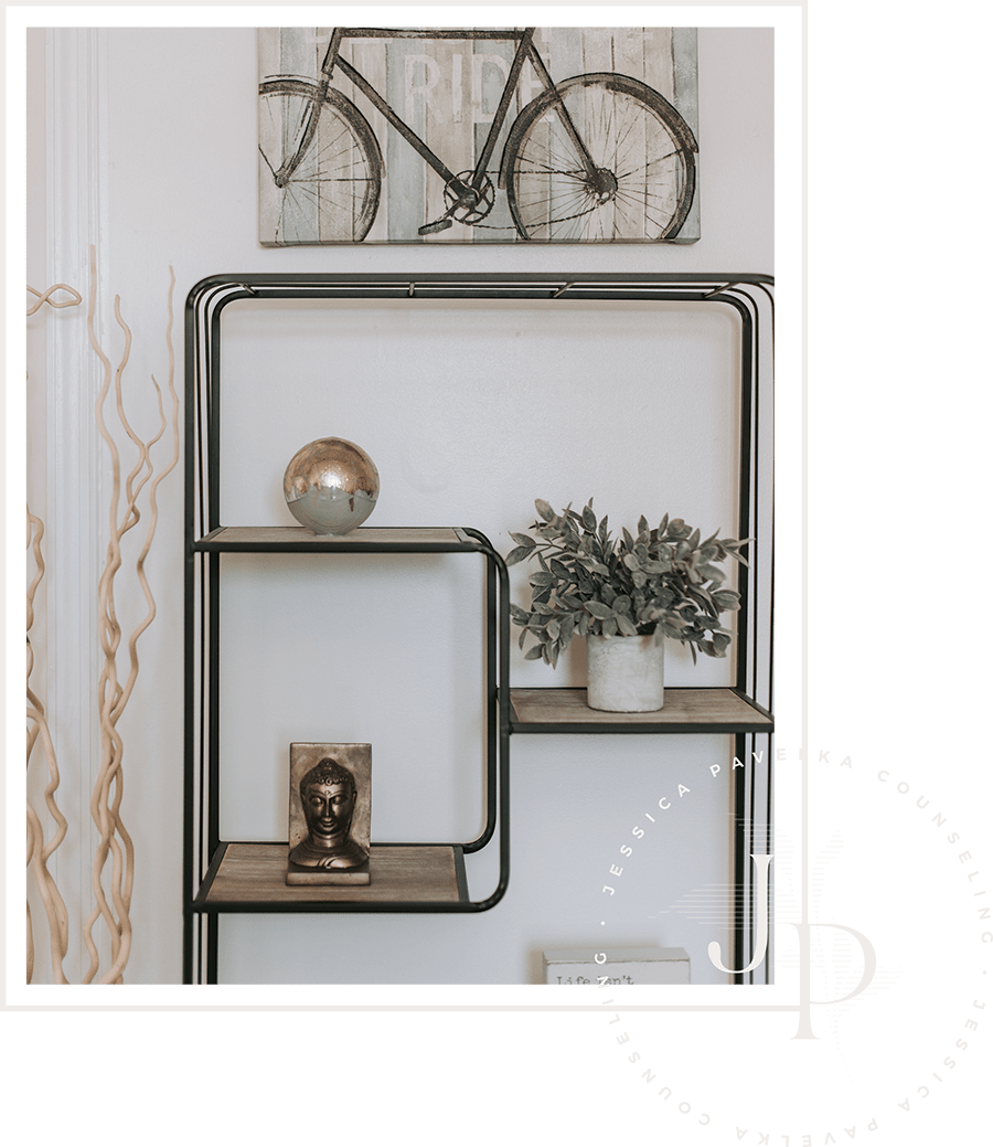 Decorative wall shelf with potted plant, small statue, and a reflective sphere, positioned below a wall art piece featuring a bicycle.