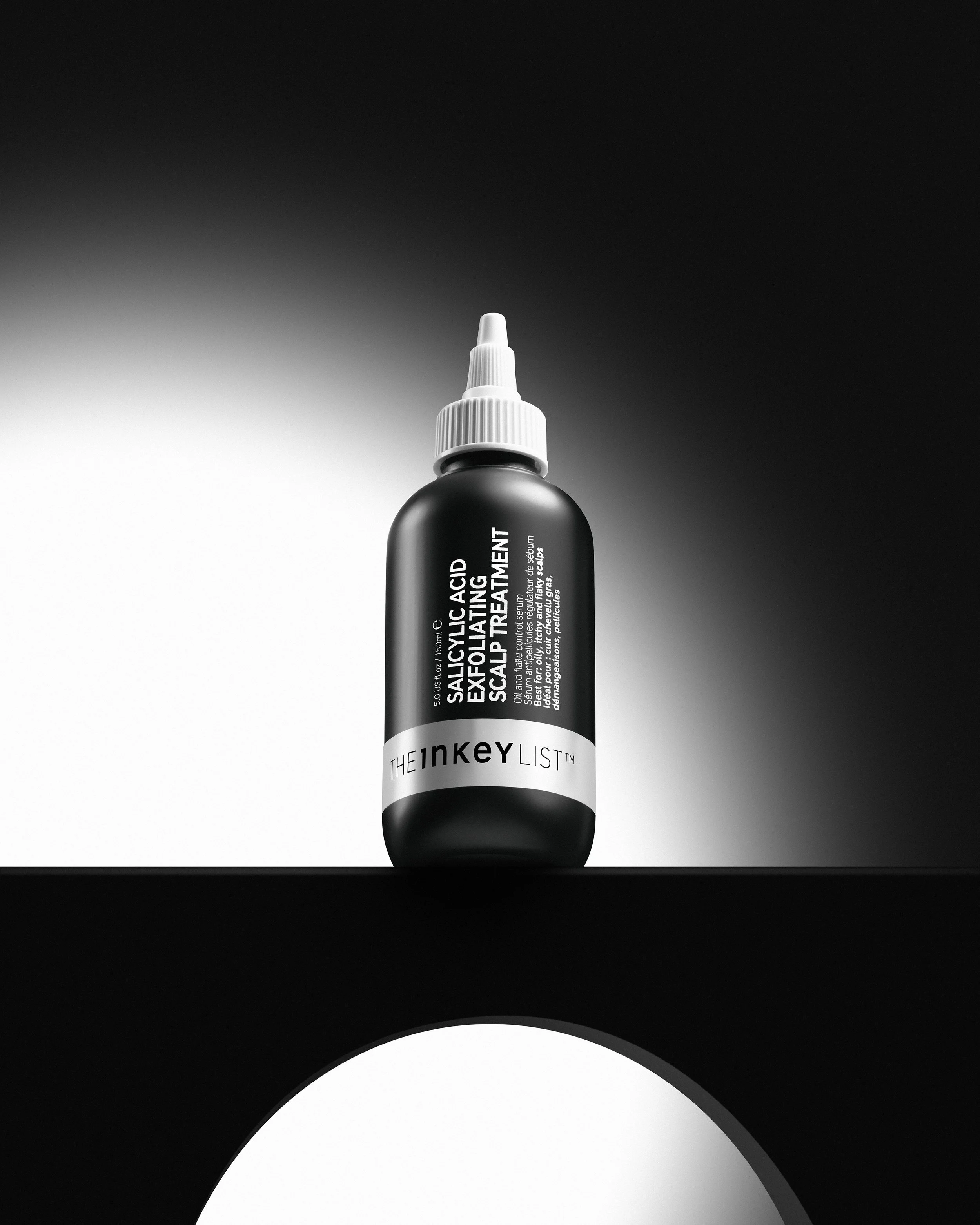 Studio skincare product photography with high-contrast lighting and minimal black background.