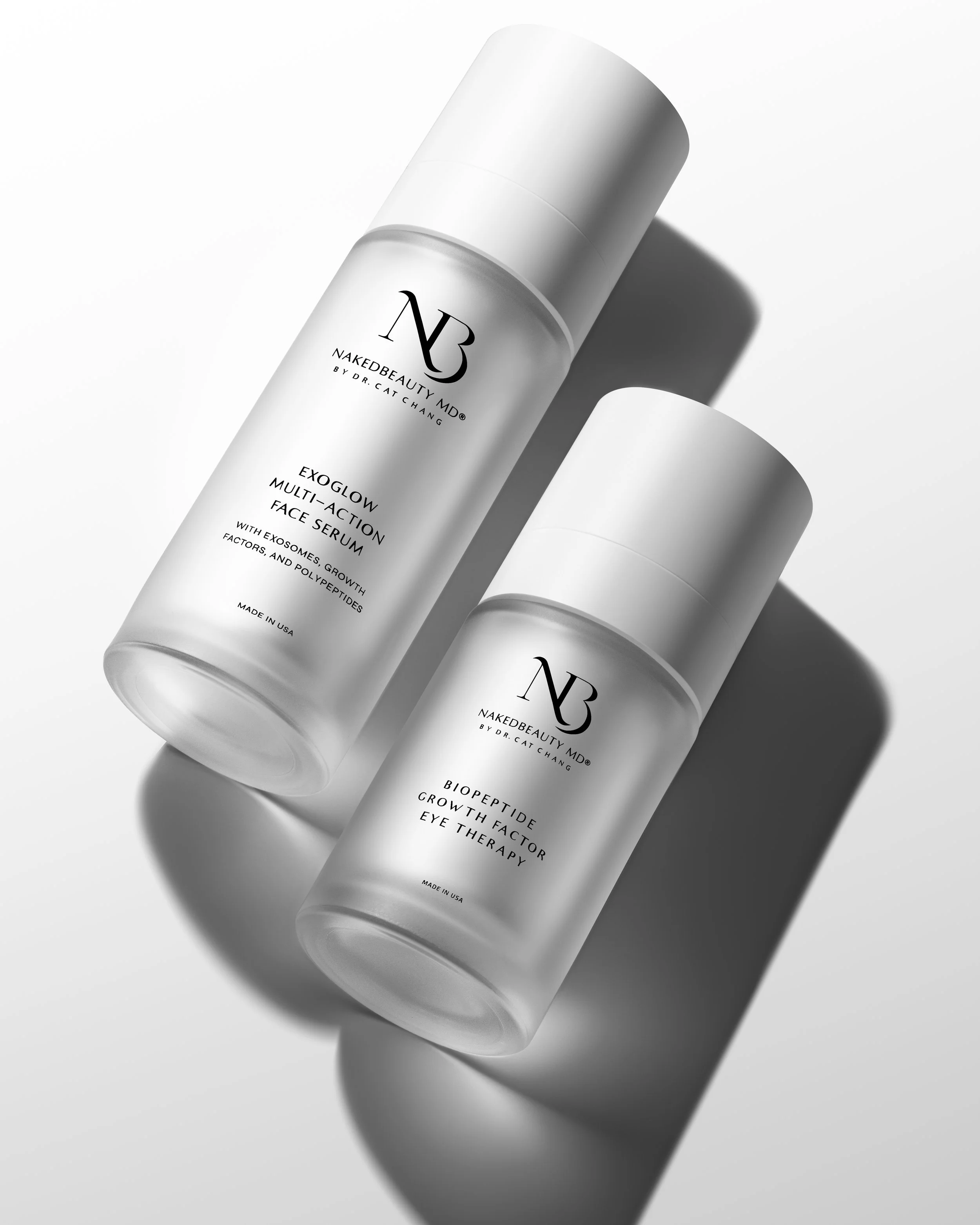 Two white bottles of skincare products with black text, shadows cast on a white surface.