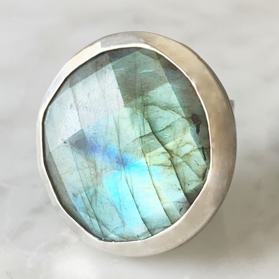 ALI KATE RING  A substantial rose-cut Labradorite, a stone thought to impart strength and perseverance, rests inside a handcrafted bezel forged from sterling silver and sits atop a sterling silver band. @shopcarmilias 
#kimcaron #oneofakind #madebyha
