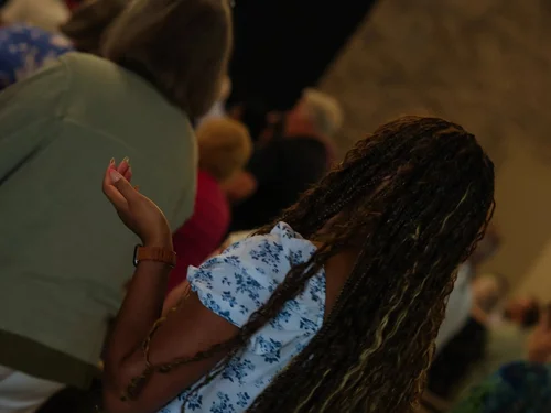 Members of the congregation worshiping with hands raised
