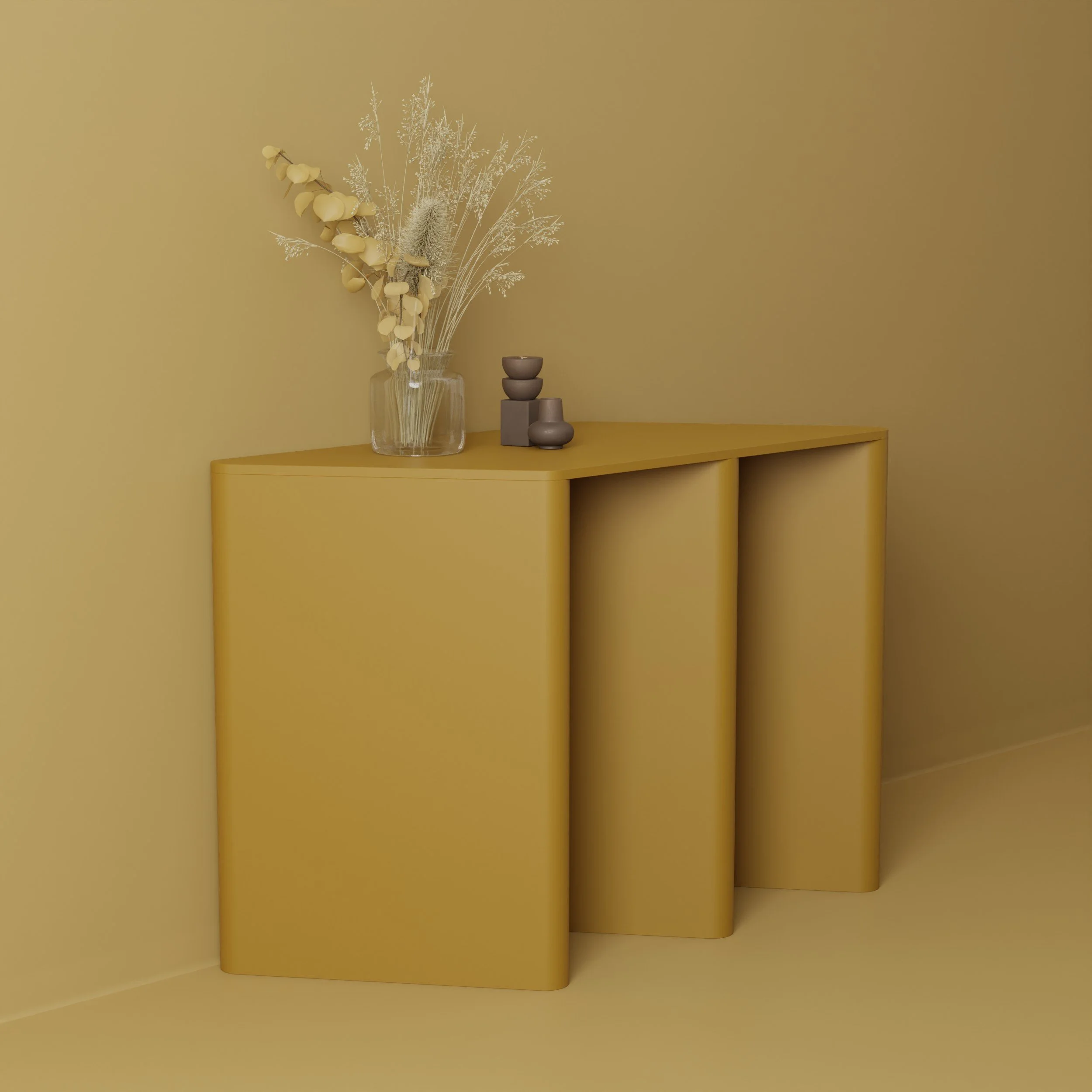 A minimalist interior scene with a yellow wall, a yellow curved table, a glass vase containing dried white and beige flowers and grasses, and nearby stack of three brown ceramic bowls and one ceramic cup.