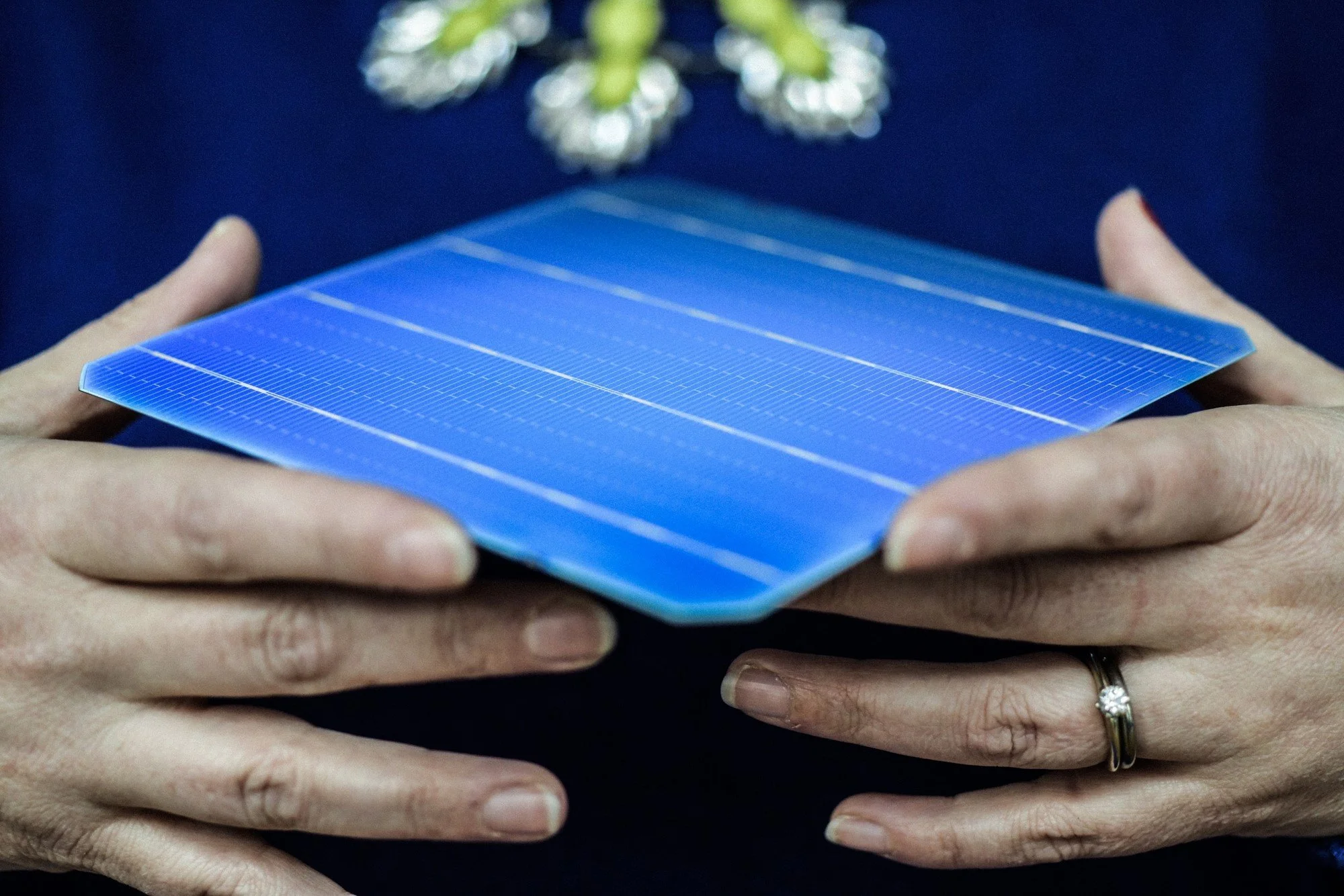 Person holding a blue solar panel close-up