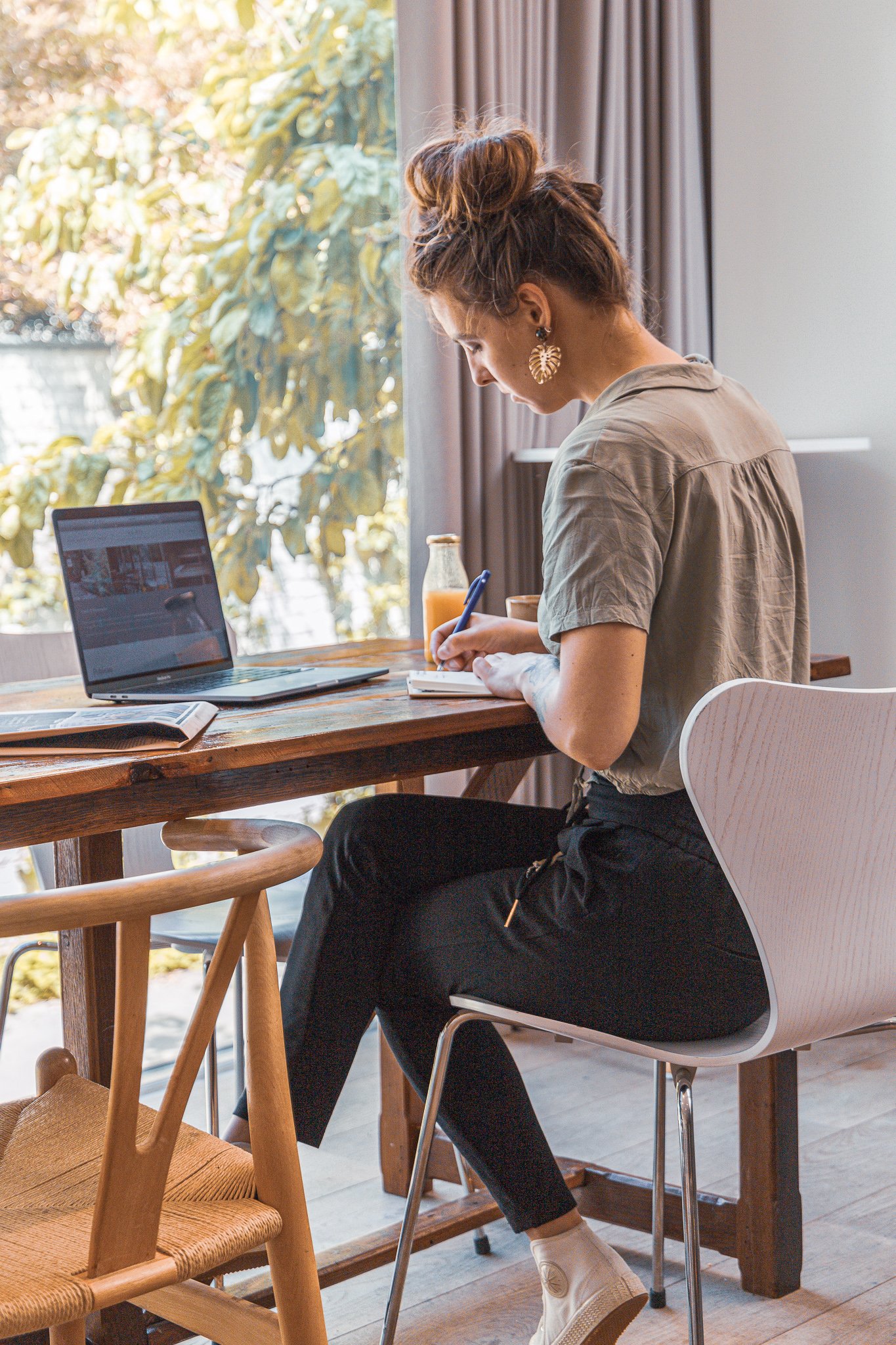 Vrouw aan tafel met laptop in co-working werkoase